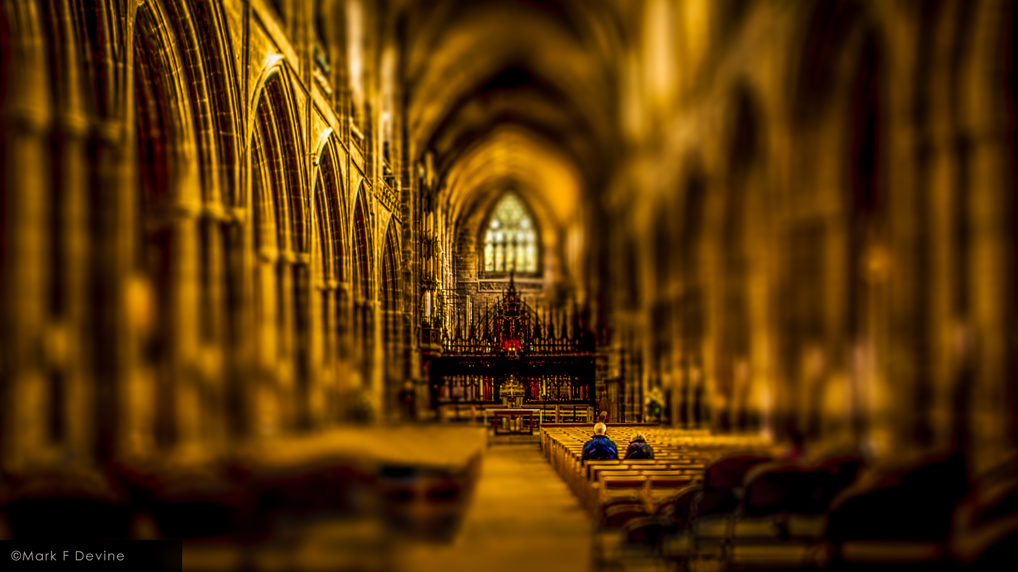 A couple in prayerful contemplation in the nave of Chester Cathedral in Chester, England.